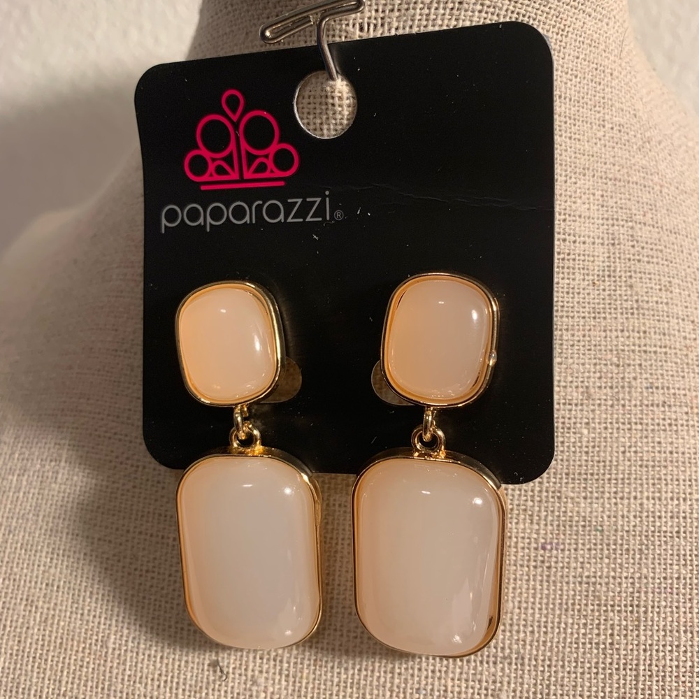 Gold and cream clip on earrings .